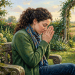 Woman praying with rosary beads in a church pew